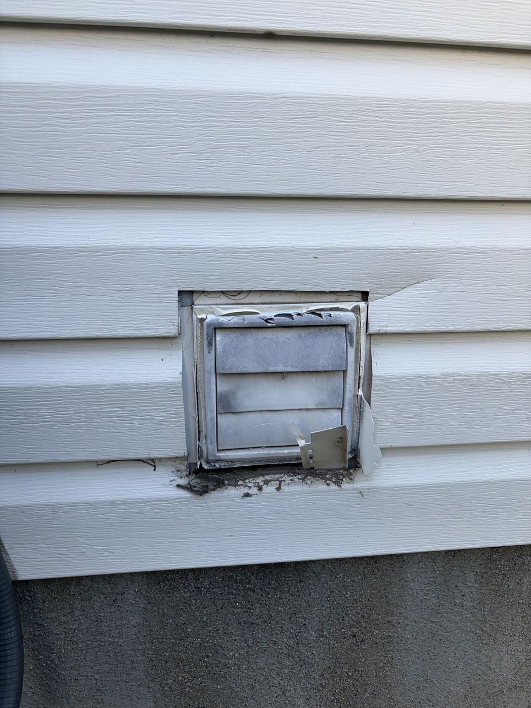 Old worn intake vent cover on vinyl wall before replacement