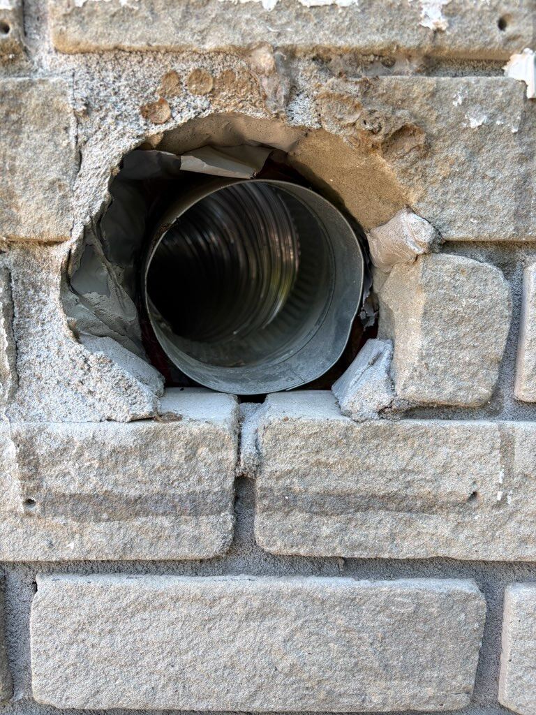 Crumbling brick opening with a loose galvanized duct inside