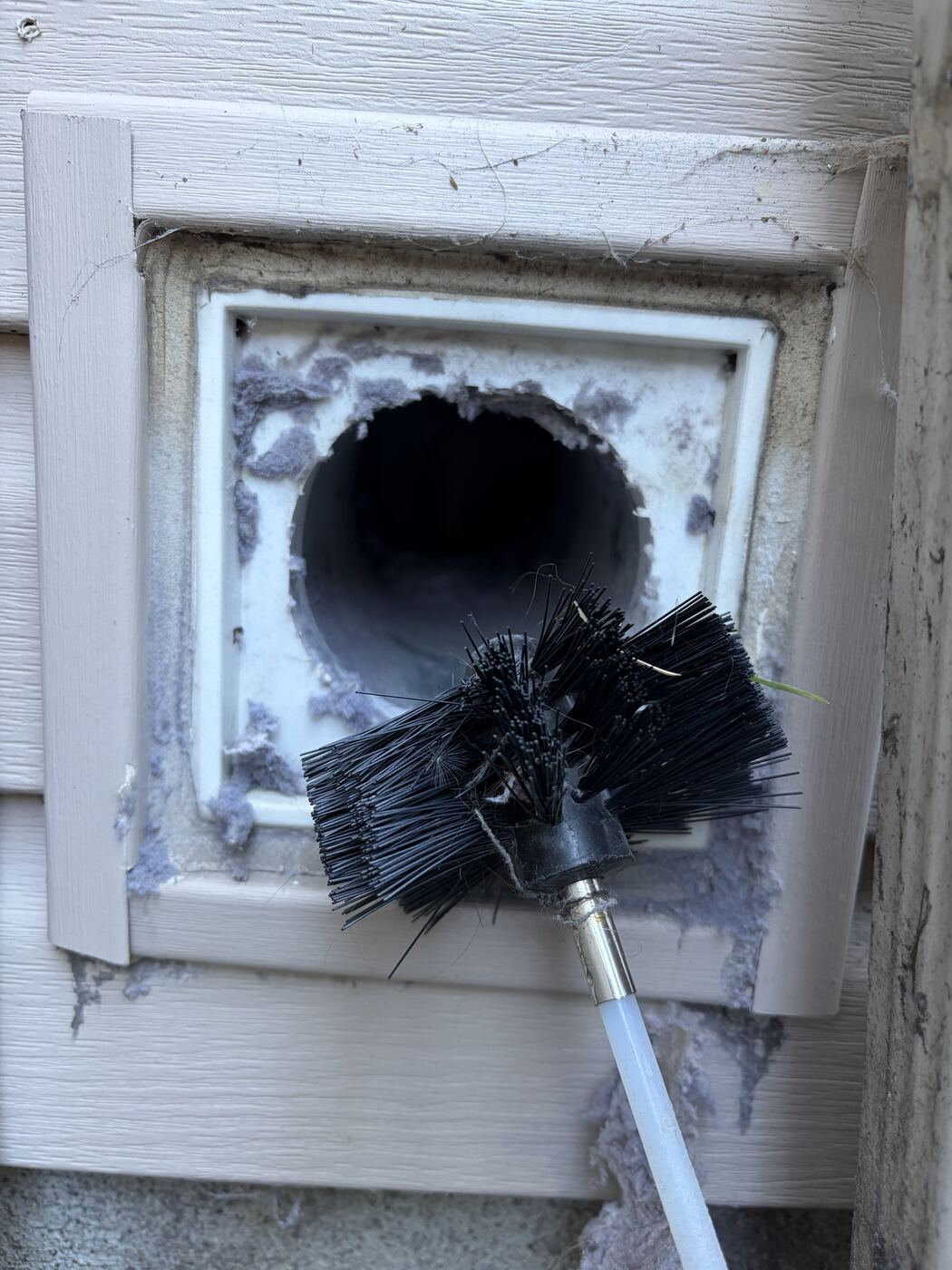 Rotary brush pulling packed lint out of a dryer duct