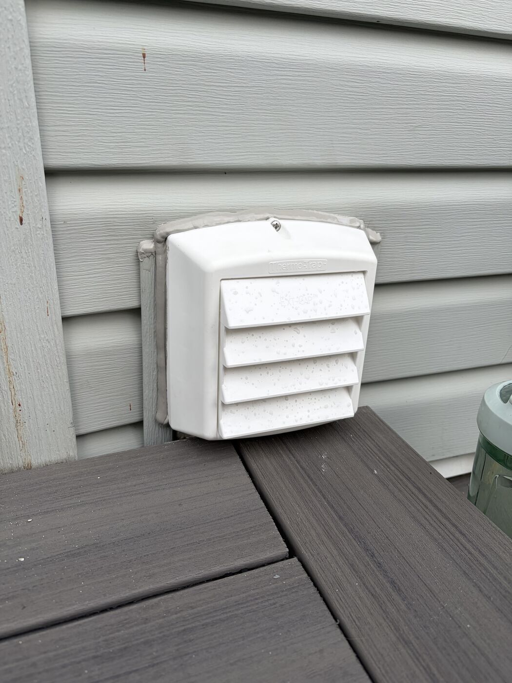 New white Thermo-Trap intake vent installed and caulked to the siding
