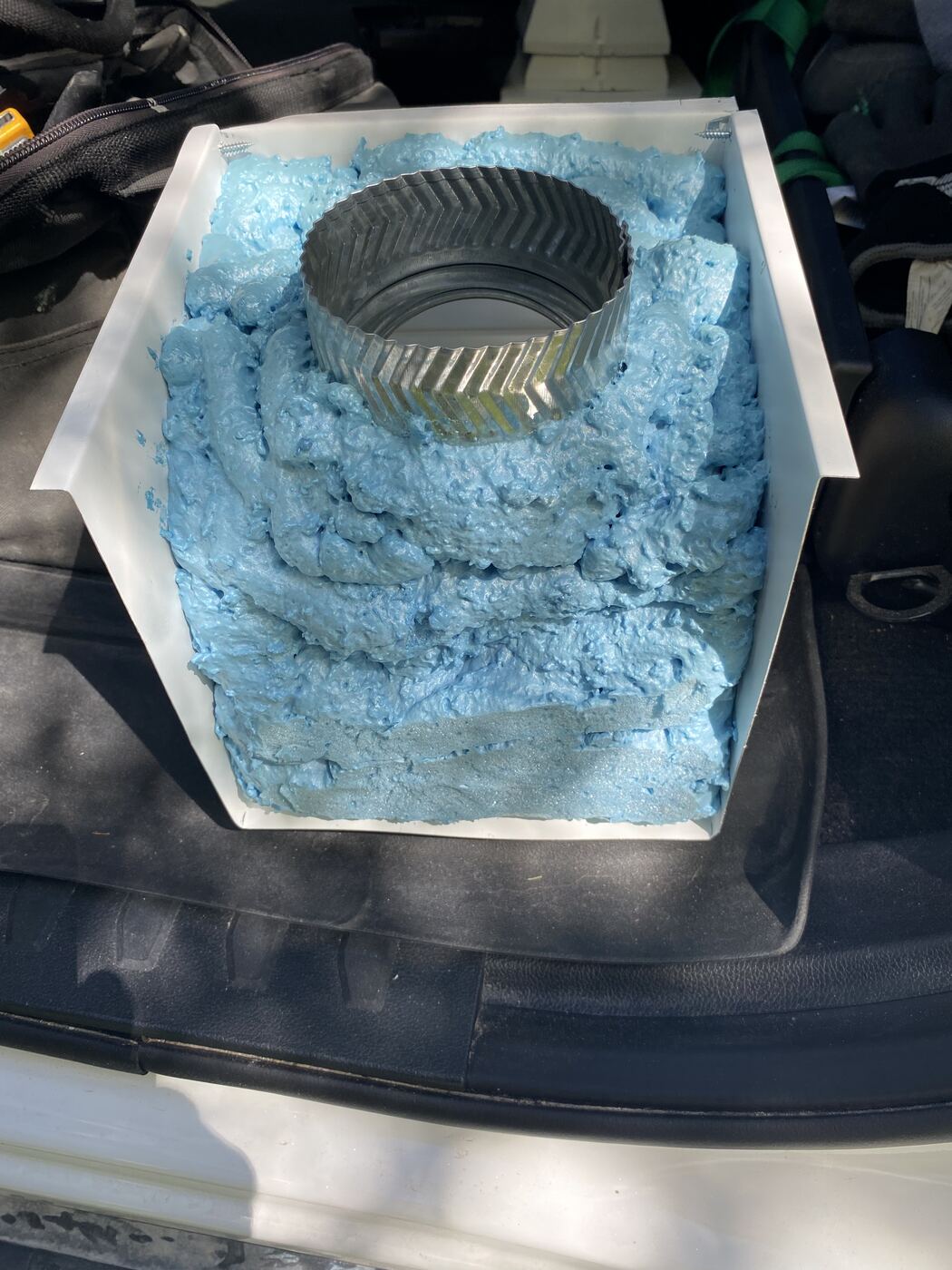 Inside of a soffit box showing the duct collar packed in closed-cell spray foam insulation