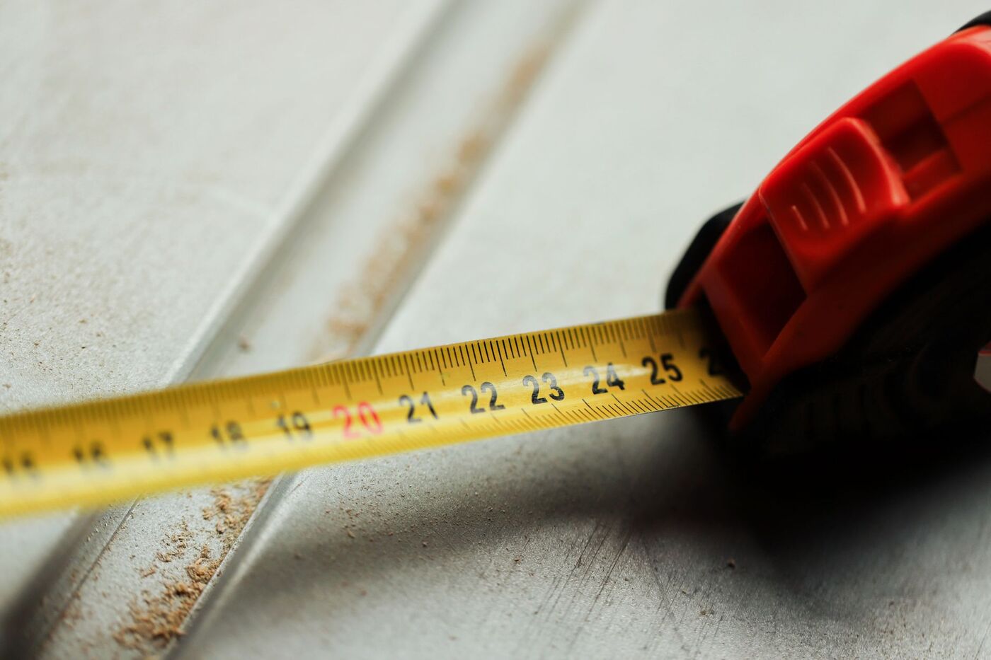 Measuring tape extended across sheet metal while planning a dryer vent duct run