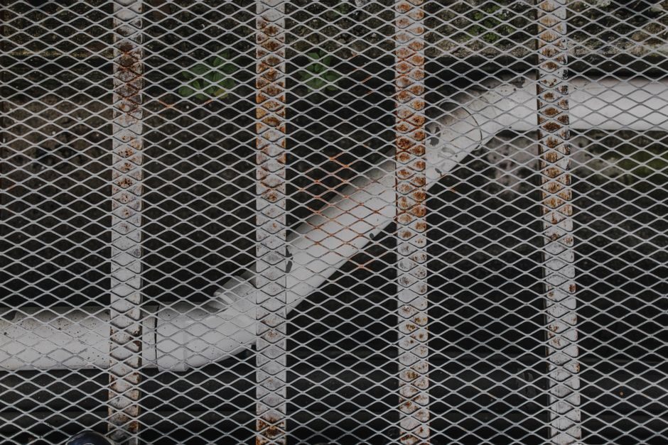 Wire mesh grill screwed over ductwork, the kind pest companies install over broken vents